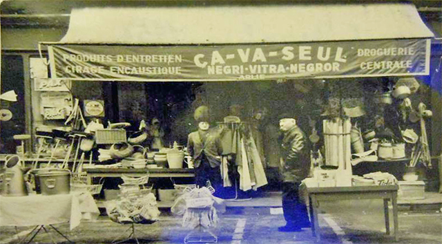 Een oude foto van een Ça va seul winkel, met het personeel ervoor staand.