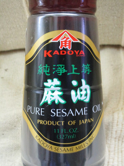 Een flesje Japanse sesam-olie, met de tekst 'Pure sesame oil'.
