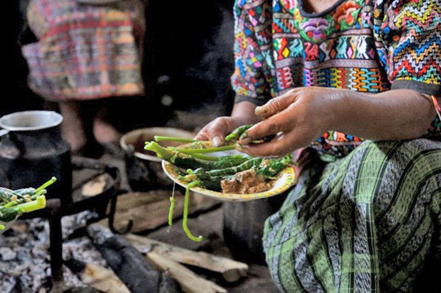 Een Mexicaanse vrouw, bezig met gekookte groente.