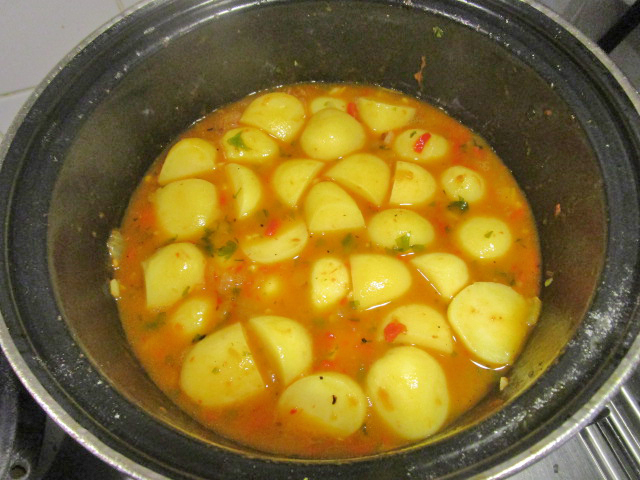 Aardappelen die stoven in paprika-saus.