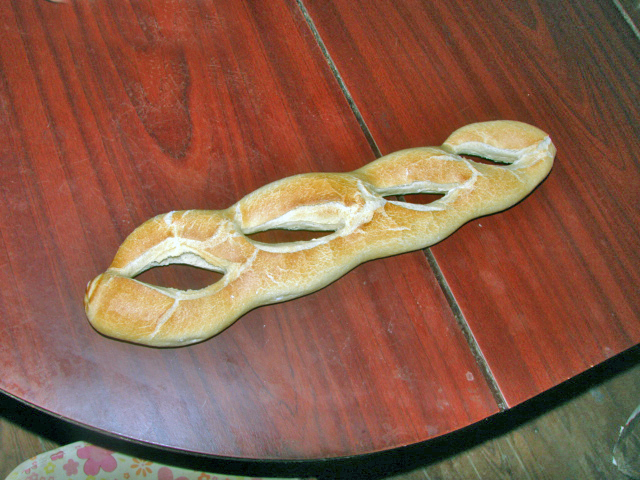 Een stokbrood, op vier plekken na elkaar opengesneden.