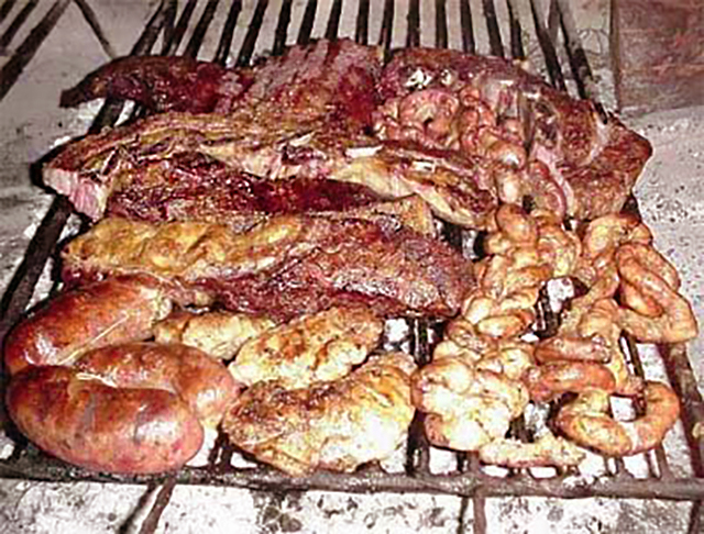 Een gril met diverse soorten vlees erop en ook darmen.