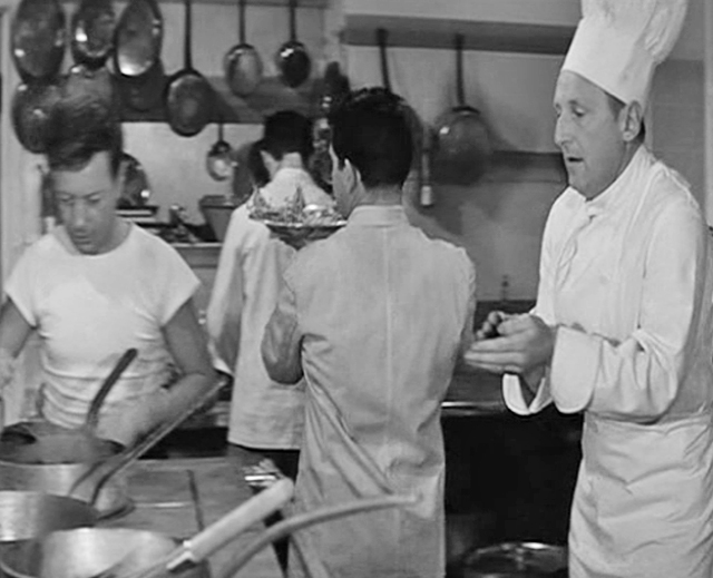 Een scène uit de film, waarop druk gewerkt wordt door een paar koks in de keuken. Bourvil is de chef.