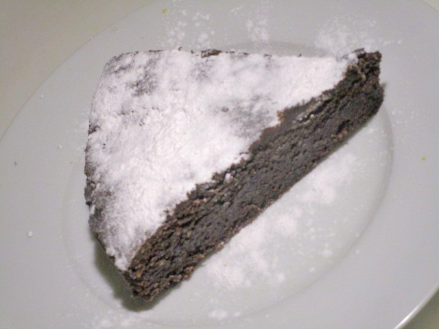 Een punt van deze chocolade-taart, bestrooid met poedersuiker.